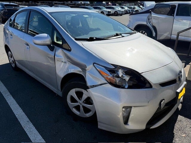 Silver Toyota Prius with a smashed front bumper, broken headlight, and crumpled front fender on the driver's side.